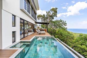 a house with a swimming pool next to the ocean at Casa del Buho in Playa Hermosa