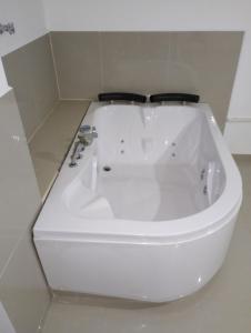uma banheira branca sentada na casa de banho em Hotel El refugio Doradal em Puerto Triunfo