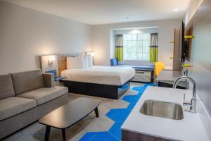 a hotel room with a bed and a couch at Microtel Inn & Suites by Wyndham Kingsland Naval Base I-95 in Kingsland +37 photos