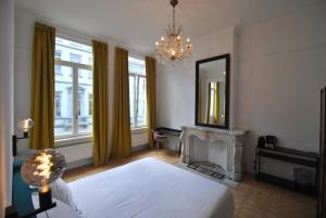 a bedroom with a bed and a mirror and a fireplace at Upstairs in Antwerp