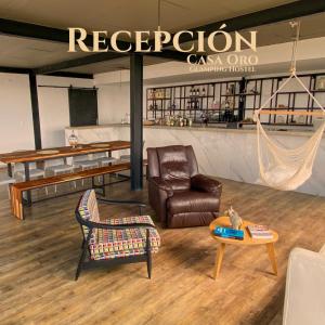Zimmer mit einem Sofa, einem Stuhl und einem Tisch in der Unterkunft Casa Oro Glamping Hostel in Guatavita
