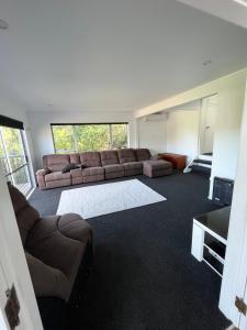 uma grande sala de estar com um sofá e uma mesa em Double Bedroom with Private Bathroom em Porirua