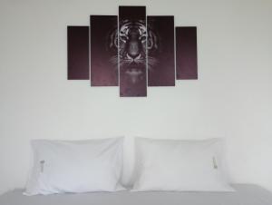 una pintura de tigre blanco y negro en la pared de un dormitorio en Hotel El refugio Doradal, en Puerto Triunfo