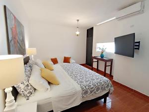 ein Schlafzimmer mit einem Bett und einem TV an der Wand in der Unterkunft Exclusivo departamento Céntrico con Terraza in Ferreñafe