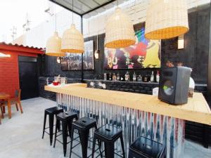 eine Bar mit schwarzen Hockern und einer Holztheke in der Unterkunft Exclusivo departamento Céntrico con Terraza in Ferreñafe