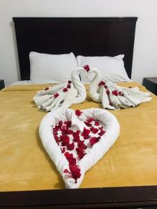 uma cama com um coração feito de toalhas em Nile Sunrise Flats em Luxor