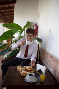 mężczyzna siedzący przy stole pijący filiżankę kawy w obiekcie La Ramada w mieście Cafayate