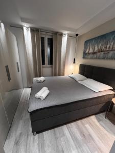 a bedroom with a bed with two towels on it at Apartmani Cvitanovic in Baška Voda