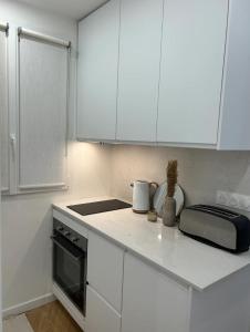 a kitchen with white cabinets and a counter top at Cocooning & Cosy Apartment in Center Paris 17 in Paris