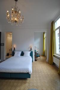 Un dormitorio con una cama grande y una lámpara de araña. en Upstairs, en Amberes