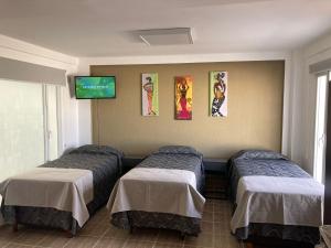 a room with two beds and a tv on the wall at Monoambiente céntrico in Comodoro Rivadavia