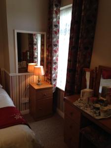 a bedroom with a bed and a dresser and a mirror at Atlantic House in Lisdoonvarna