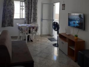 - un salon avec une table et une télévision dans l'établissement Apartamento com Vista para Mar, à Piúma