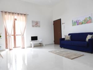 a living room with a blue couch and a tv at Casa Lumìa in Palermo