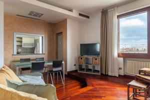 een woonkamer met een tafel en een televisie bij San Luca Fine House in Bologna