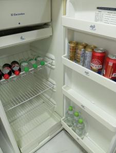 a refrigerator filled with bottles and cans of soda at Priscila II in La Paz