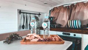 a cutting board with meat and two bottles of water at Camperita Van Life in Puerto del Carmen