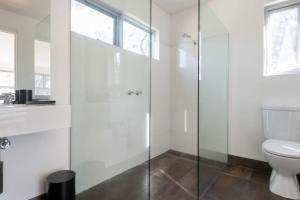 a bathroom with a toilet and a glass shower at Mr Wooden Box Bush Retreat 5 minutes from the CBD in Inveresk +18 photos