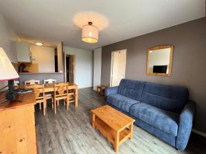 ein Wohnzimmer mit einem blauen Sofa und einem Tisch in der Unterkunft Résidence Hauts De Peyragudes Mp - 2 Pièces pour 6 Personnes 894 in Germ
