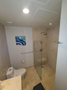 a bathroom with a toilet and a glass shower at Moderno departamento en Playa del Carmen in Playa del Carmen