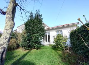 a white house with a tree in the yard at Maison indépendante avec jardin in Pessac