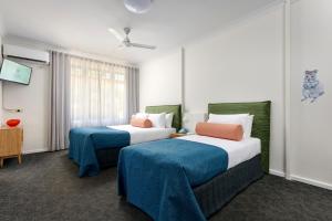una camera d'albergo con due letti e una finestra di Baileys Parkside Motel by VetroBlu a Perth
