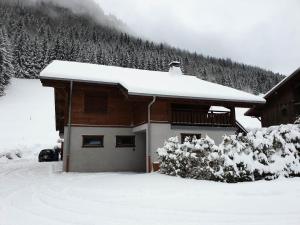 un bâtiment recouvert de neige avec des arbres en arrière-plan dans l'établissement Chalet La Passionata - Chalets pour 8 Personnes 154, à Morzine