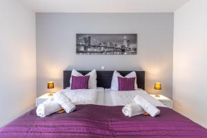 a bedroom with a large bed with purple sheets at Arbeitsplatz, Balkon, Tiefgarage nähe neue Messe in Leipzig