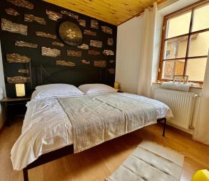 - une chambre avec un lit et un mur avec une horloge dans l'établissement Schiller Haus&Restaurant, à Spišská Belá