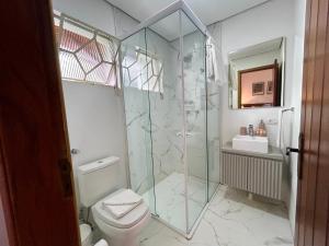 a bathroom with a glass shower and a toilet at Casa Três Rios - Campos do Jordão in Campos do Jordão