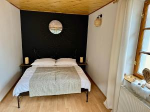 een slaapkamer met een bed met een zwarte muur bij Schiller Haus&Restaurant in Spišská Belá