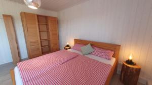 um quarto com uma cama vermelha e branca com 2 candeeiros em Haus Feldblick am Wasser em Berg