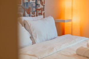 a bed with white sheets and pillows in a room at Cozy 1 Bedroom in the heart of Dubai Marina in Dubai