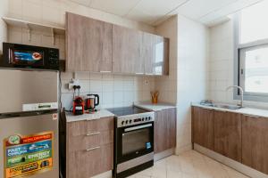 a kitchen with a stove and a refrigerator at Cozy 1 Bedroom in the heart of Dubai Marina in Dubai