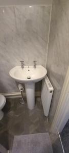 La salle de bains est pourvue d'un lavabo blanc et de toilettes. dans l'établissement Serene Homes Sheffield, Private Ensuite Velux Room, à Hillsborough