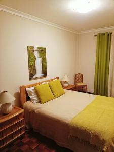 a bedroom with a large bed with yellow pillows at Sesimbra Flat in Sesimbra