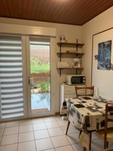 a kitchen with a window and a table and a microwave at le gite des vignes Studio tout confort 1 chambre dans le vignoble Franche Comte Arbois in Arbois