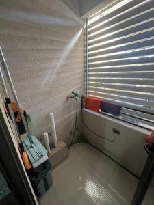 a small bathroom with a window with blinds on it at Calama: Tranquilidad Urbana in Calama