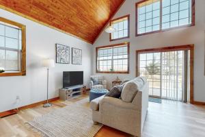 ein Wohnzimmer mit einem Sofa und einem TV in der Unterkunft Vineyard Sanctuary in Penn Yan
