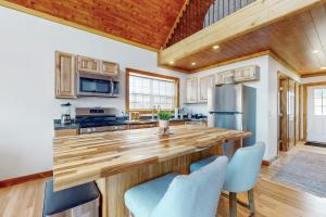 a kitchen with a wooden counter top and blue chairs at Vineyard Sanctuary in Penn Yan +17 photos