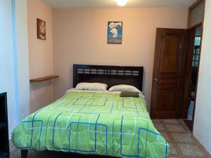 1 dormitorio con 1 cama con edredón verde en Tumbaco Ritz, en Quito