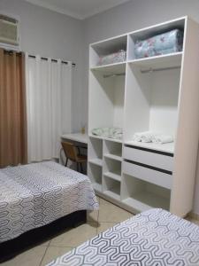 um quarto com 2 camas e um armário branco em Wana casa 2 Requinte e conforto em Sao Jose do Rio Preto