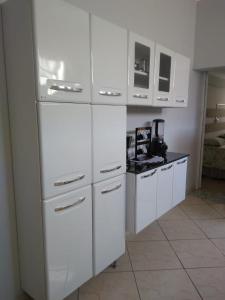 una cocina con encimeras blancas y armarios blancos en Wana casa 2 Requinte e conforto, en São José do Rio Preto