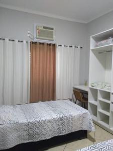 um quarto com uma cama, uma secretária e uma janela em Wana casa 2 Requinte e conforto em São José do Rio Preto