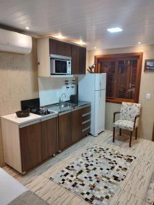 a kitchen with a white refrigerator and a sink at Apto Dom Victor 101 in Gramado