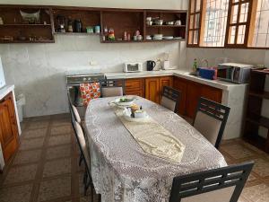 cocina con mesa y algunas sillas y mesa en Tumbaco Ritz, en Quito