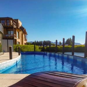 une grande piscine à côté d'un bâtiment dans l'établissement HUAPI 1, à Dina Huapi