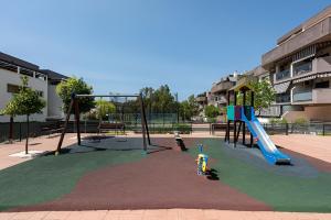un parque infantil vacío con tobogán y columpios en Ven descansa y conoce Málaga en Málaga
