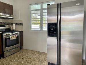 a kitchen with a stainless steel refrigerator and a stove at Nela’s Beach House in Arecibo +45 photos