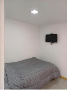 a bedroom with a bed with a tv on the wall at Lo de Tomy in Río Grande +4 photos